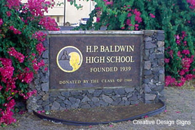 Baldwin High School - Sandcarved granite with gold leaf mounted on blue rock wall.