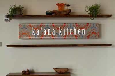 Ka'ana Kitchen - Internall lit LED cabinet with push-through acrylic letters, custom painted decorative pattern.
