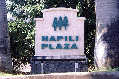 Napili Plaza - Tarnished bronze letters mounted onto stucco wall.