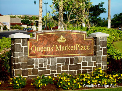 Queens Marketplace - Monument sign with engraved gold leaf graphics. Stone base.